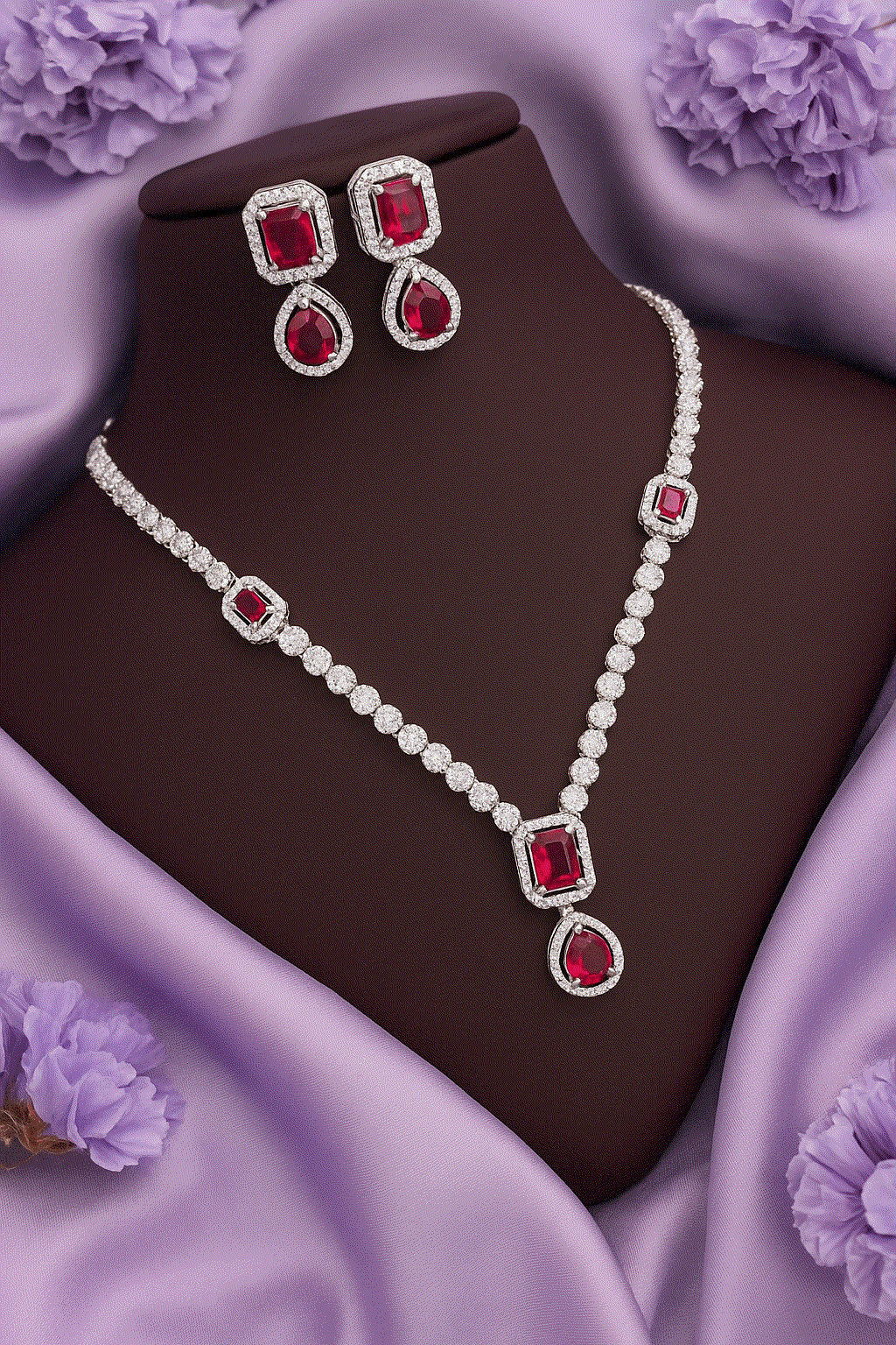 Regal Ruby Red CZ Diamond white gold tone bridal necklace and drop earrings set on purple satin background