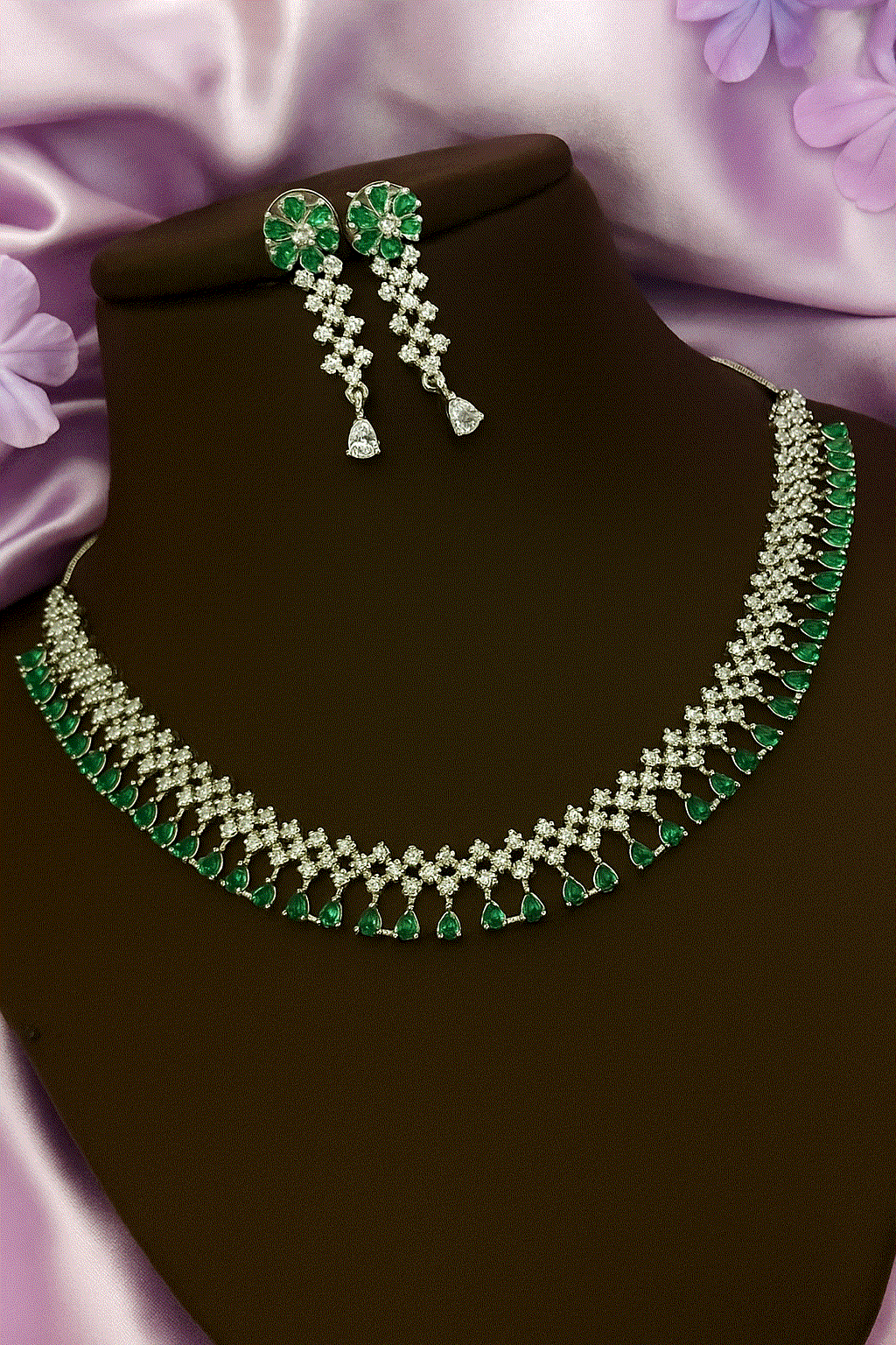Luxury emerald green and diamond-cut cubic zirconia bridal necklace and earring set on display