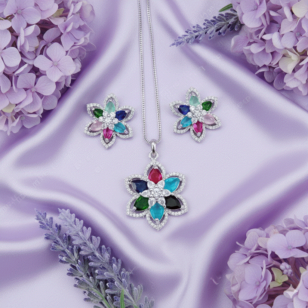Vibrant multi-color floral pendant and stud earrings set with marquise-cut CZ stones and rhodium plating on lavender silk background.