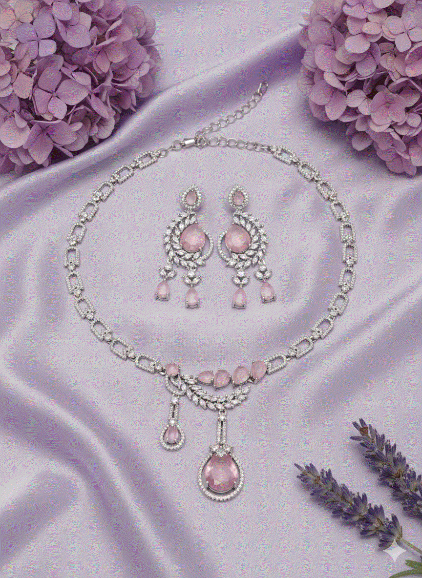 Intimate jewelry set featuring rose gold plated leaf motif necklace with cubic zirconia and matching earrings on lavender silk background