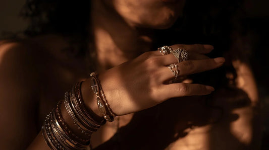 Close-up of a hand wearing multiple rings and bracelets symbolizing jewelry symbolism and personal meaning