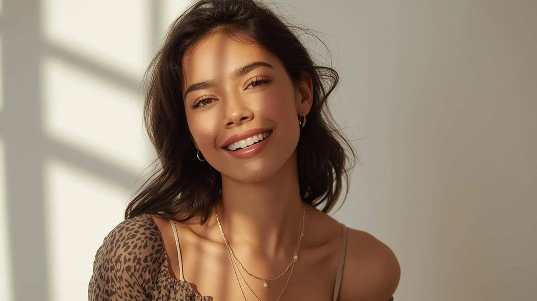 smiling woman wearing minimalist everyday jewelry with gold necklaces and hoop earrings