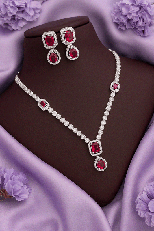 Regal Ruby Red CZ Diamond white gold tone bridal necklace and drop earrings set on purple satin background