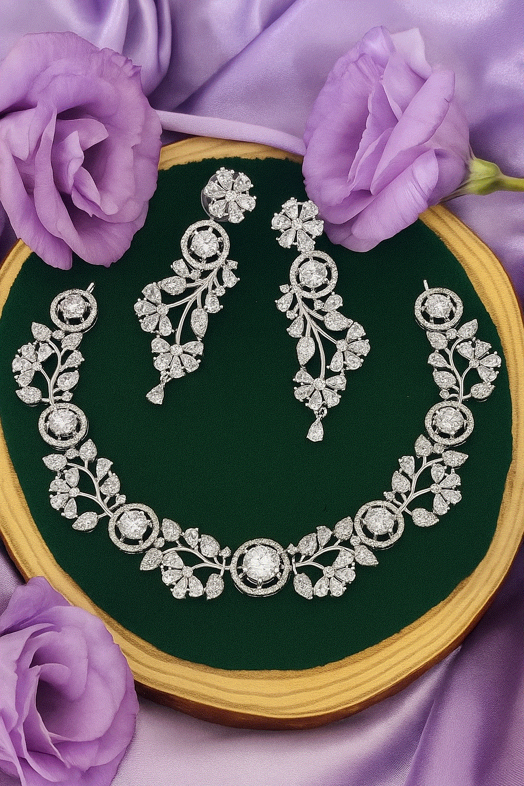Intimate Luxury CZ Diamond Necklace Set with earrings in silver-plated floral vine design on green velvet background with purple flowers