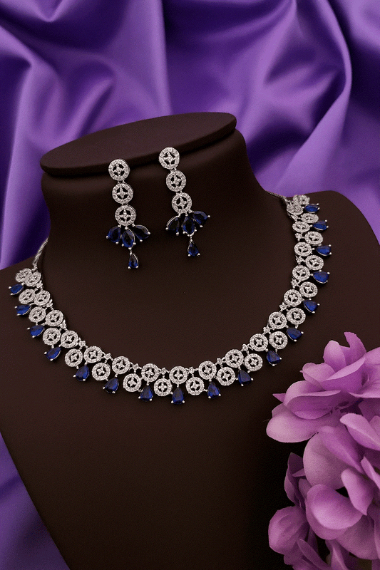 Dazzling Sapphire Blue Drop CZ Choker Set with silver-toned bridal necklace and matching dangling earrings on black display against purple fabric background