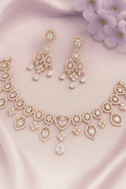 Luxury CZ Intimate Jewelry Set with gold-plated heart and teardrop cubic zirconia necklace and chandelier earrings on pink fabric background