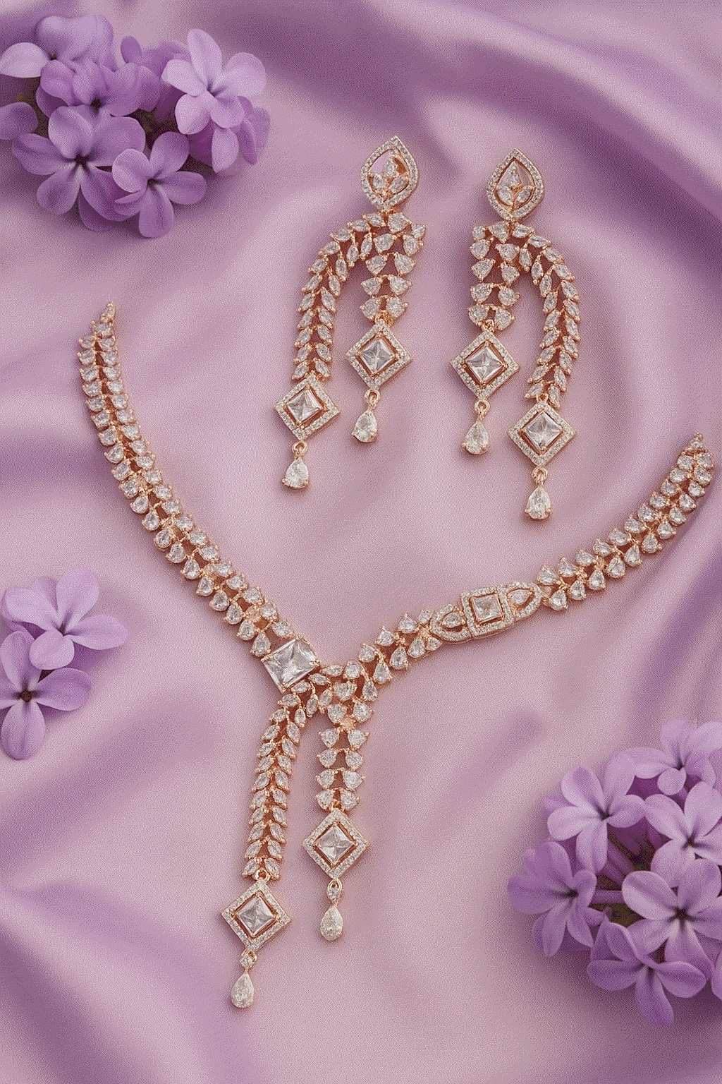 Luxury CZ Intimate Jewelry Set rose gold V-neck bridal necklace with cubic zirconia and matching diamond shape statement earrings on purple fabric background