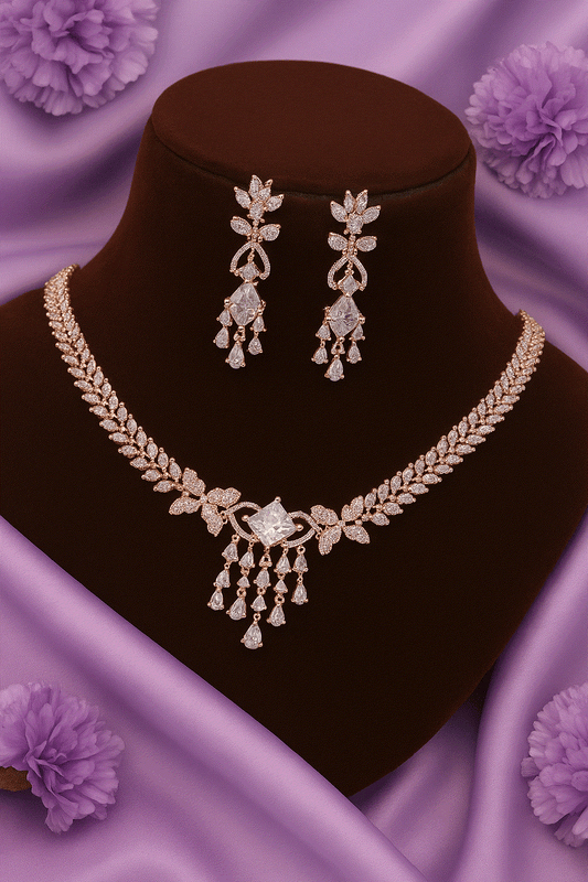 Luxury CZ intimate jewelry set with rose gold leaf vine bridal necklace and diamond look chandelier earrings on a display bust with purple floral background