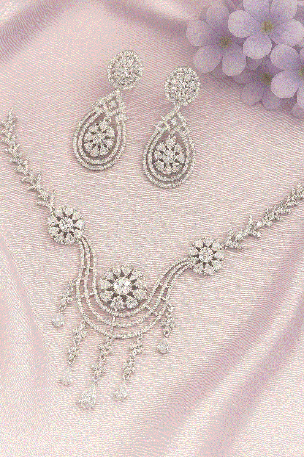 Luxury CZ Intimate Jewelry Set with rhodium-plated floral bridal necklace and chandelier earrings on pink satin background