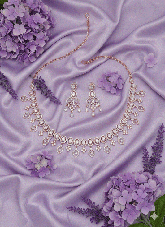 Intimate Jewelry rose gold plated oval link necklace set with matching chandelier earrings on purple satin background