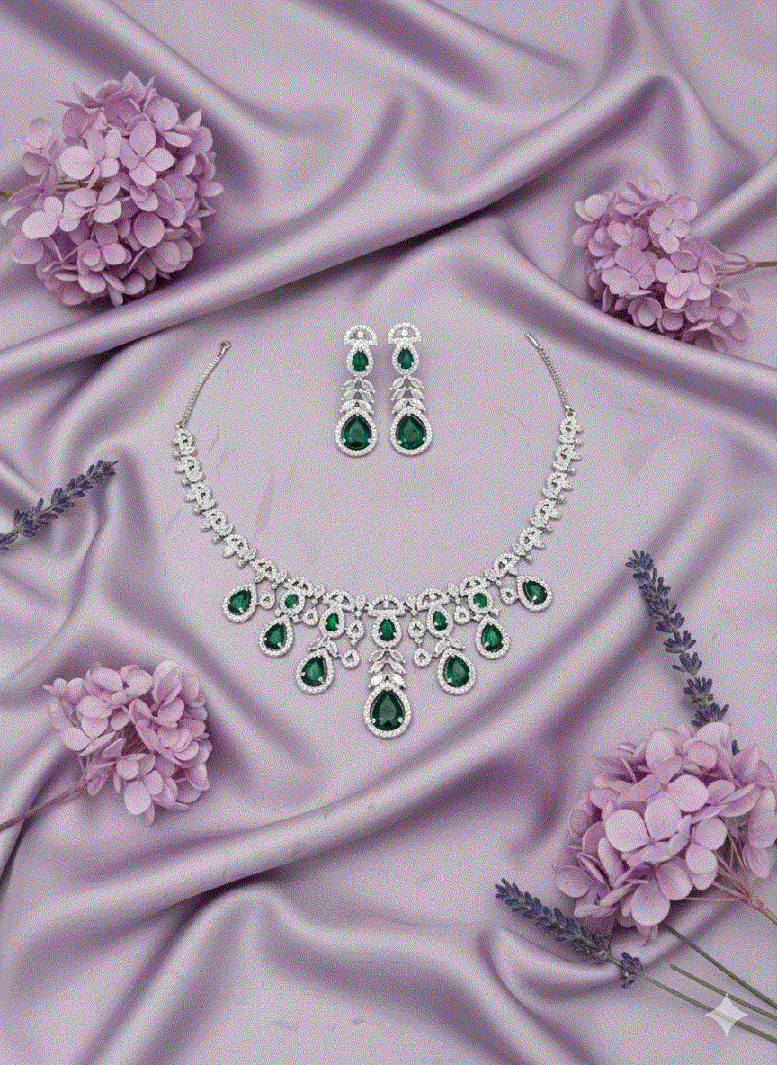 Intimate Jewelry necklace set with emerald green and white CZ drop stones on rhodium plated silver background