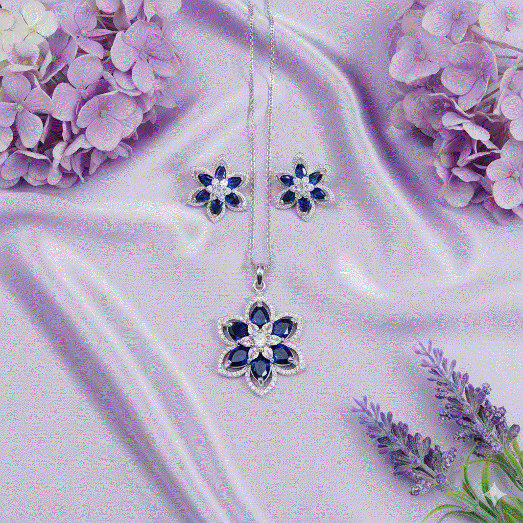 Elegant intimate jewelry sapphire blue floral pendant and stud earring set with rhodium plating on lavender satin background