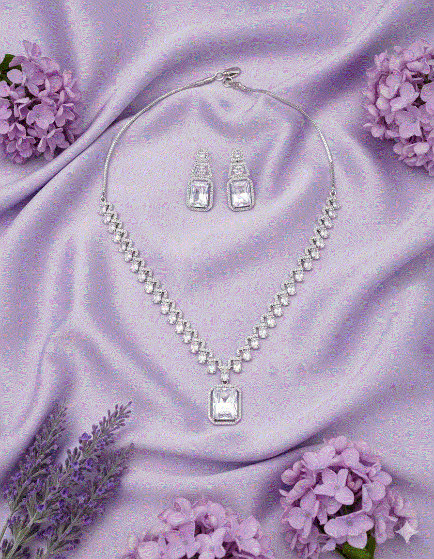 Intimate Jewelry luxury rhodium plated clear CZ geometric pendant necklace and earrings set on purple satin with flowers