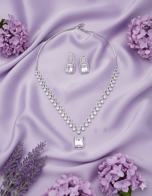 Intimate Jewelry luxury rhodium plated clear CZ geometric pendant necklace and earrings set on purple satin with flowers