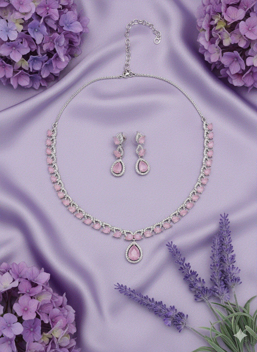 Romantic intimate jewelry set with pink CZ teardrop pendant necklace and matching earrings on purple silk background