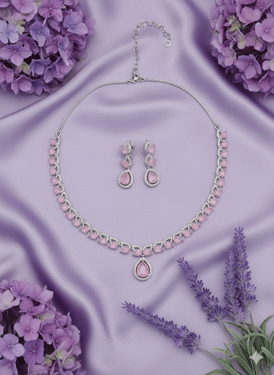 Romantic intimate jewelry set with pink CZ teardrop pendant necklace and matching earrings on purple silk background
