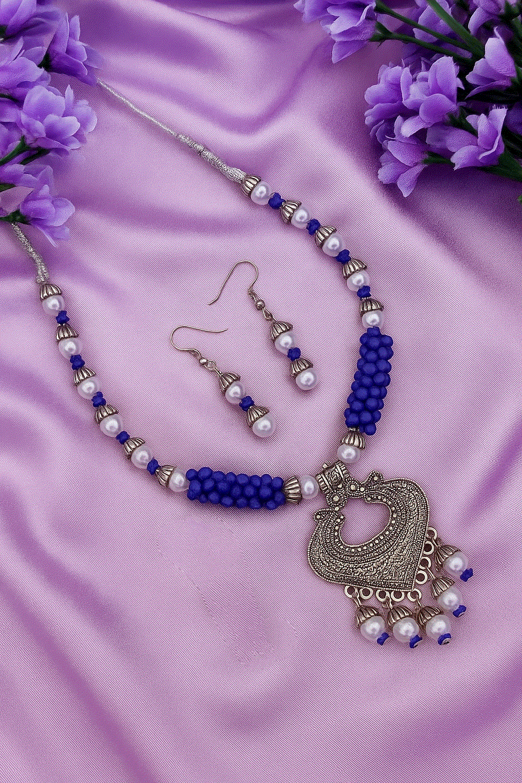 Bohemian Blue Pearl oxidized silver tone necklace and dangler earrings on purple fabric with floral accents