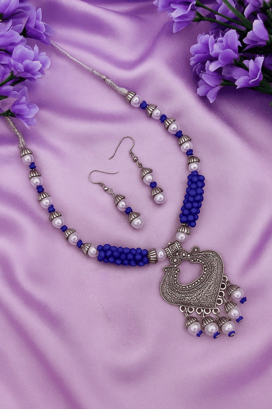 Bohemian Blue Pearl oxidized silver tone necklace and dangler earrings on purple fabric with floral accents
