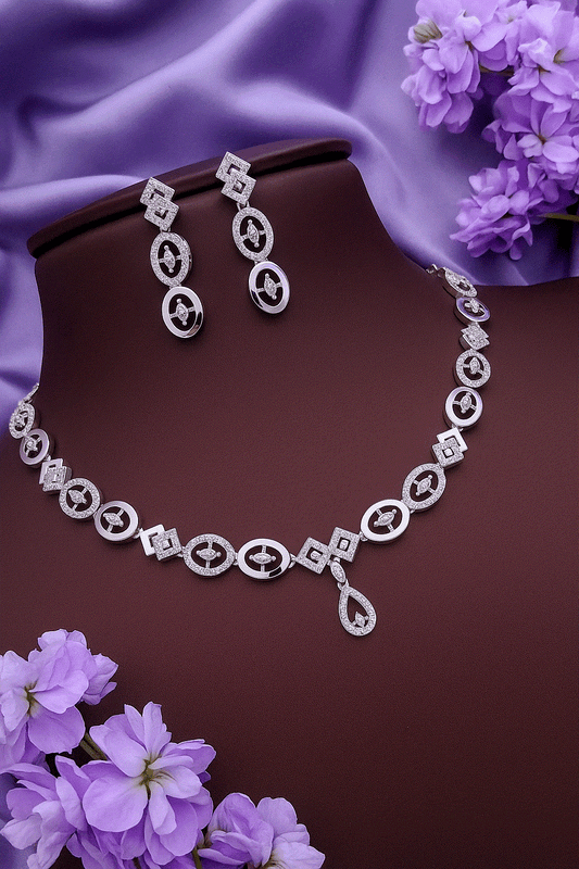 Geometric CZ diamond necklace and dangler earrings set in silver tone with sparkling micro-pave stones on purple background