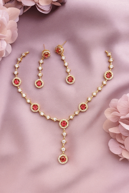 Gold-plated ruby CZ Y-necklace and earrings set on pink fabric background
