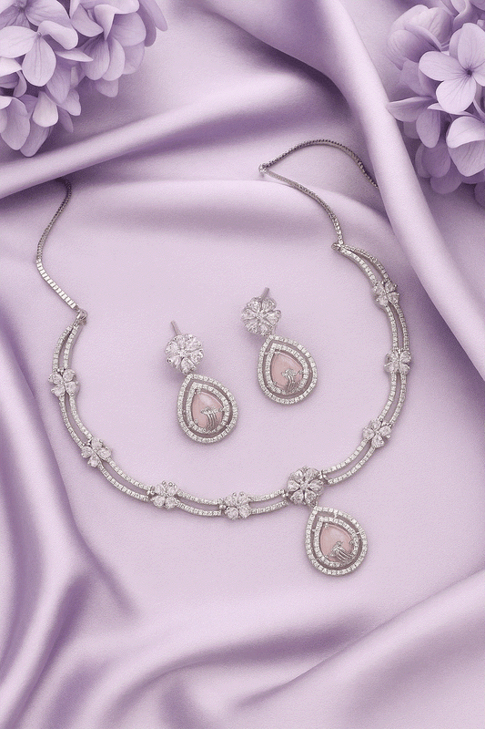 Elegant Intimate Jewelry pink CZ floral drop necklace and earrings set with rhodium plating on lavender silk background